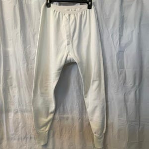 Peut inclure: Une paire de caleçons longs thermiques blanc uni dotée d'une ceinture élastique côtelée, d'une ouverture à braguette verticale sur le devant et de poignets côtelés ajustés aux chevilles. Le vêtement est en tissu tricoté texturé.