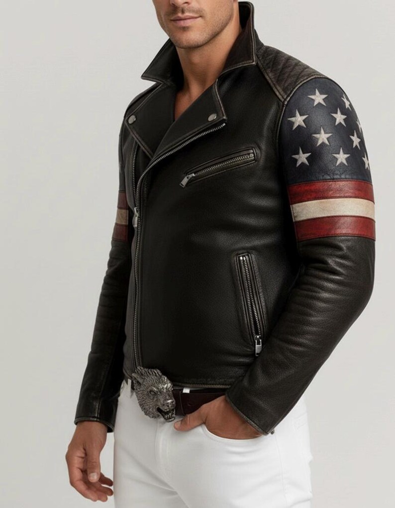 May include: Black leather jacket with an asymmetrical zipper, featuring an American flag design on the sleeves. The jacket has a quilted shoulder detail and a silver wolf buckle on the belt. The jacket is worn with white pants.