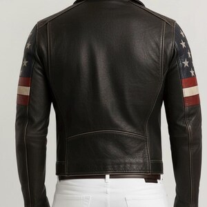 May include: Black leather jacket with American flag design on the sleeves. The jacket features a classic biker style with a notched collar, zipper closure, and a tailored fit. The sleeves display a pattern of white stars and red and white stripes.