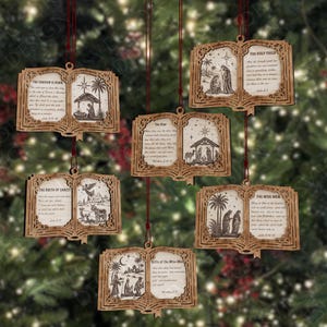 May include: Five laser-cut wooden book-shaped ornaments featuring intricate filigree borders and engraved nativity scenes with biblical text. Each ornament hangs from a thin red string, displaying illustrations of the birth of Christ and the wise men.