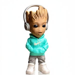 Op de afbeelding: Een Groot-beeldje met een turquoise hoodie met een wit Nike-logo, een grijze broek, witte sneakers en een grijze koptelefoon. Het beeldje heeft een houten textuur en zwarte ogen, tegen een witte achtergrond.