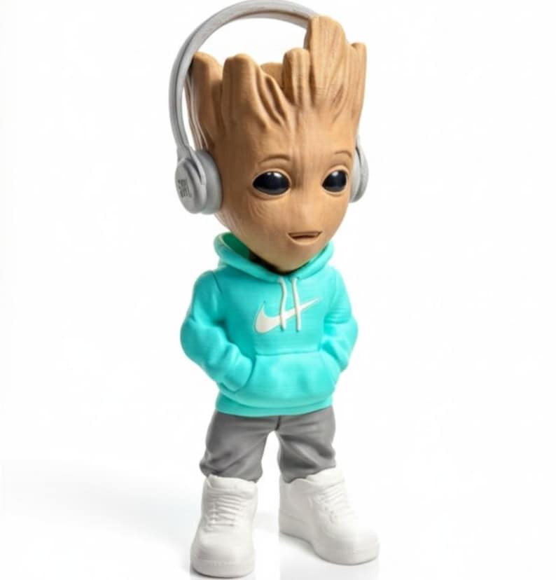 Op de afbeelding: Een beeldje van Groot met een turquoise hoodie met een wit Nike-logo, een grijze broek en witte sneakers. Het beeldje heeft een koptelefoon en een glimlachende uitdrukking. Een verzamelobject.