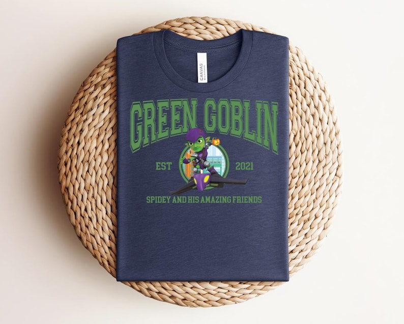 May include: Navy blue t-shirt featuring the text "GREEN GOBLIN" in green, with a cartoon illustration of the Green Goblin character. The shirt also includes the text "EST 2021" and "SPIDEY AND HIS AMAZING FRIENDS".