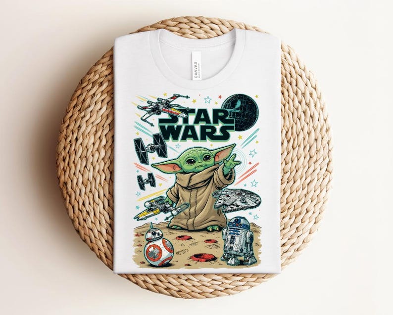 Puede incluir: Una camiseta blanca con un estampado gr&aacute;fico colorido de Star Wars. El dise&ntilde;o incluye un personaje verde con una t&uacute;nica beige, un X-wing, un caza TIE, el Halc&oacute;n Milenario, BB-8, R2-D2 y la Estrella de la Muerte sobre un fondo de estrellas y l&iacute;neas.
