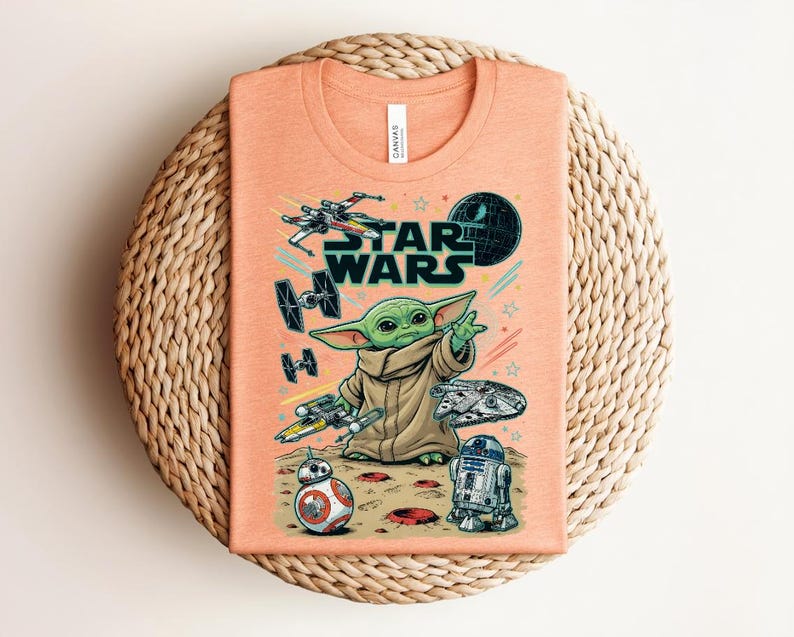 Puede incluir: Una camiseta de color melocot&oacute;n con un estampado gr&aacute;fico de Star Wars. El dise&ntilde;o incluye a Grogu, un X-wing, un caza TIE, el Halc&oacute;n Milenario, BB-8, R2-D2 y la Estrella de la Muerte. El texto STAR WARS aparece en letras negras sobre el personaje.
