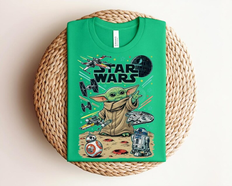 Puede incluir: Una camiseta de color verde brillante con un estampado gr&aacute;fico de Star Wars. El dise&ntilde;o incluye a Grogu, la Estrella de la Muerte, un X-wing, cazas TIE, el Halc&oacute;n Milenario, BB-8 y R2-D2 sobre una superficie arenosa con l&iacute;neas de movimiento y estrellas.