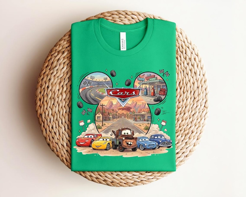 Puede incluir: Una camiseta de color verde brillante con un estampado gr&aacute;fico del logotipo de Disney Pixar Cars y personajes como Rayo McQueen, Mate y otros. El dise&ntilde;o incluye escenas circulares de una pista de carreras y una gasolinera sobre los personajes.