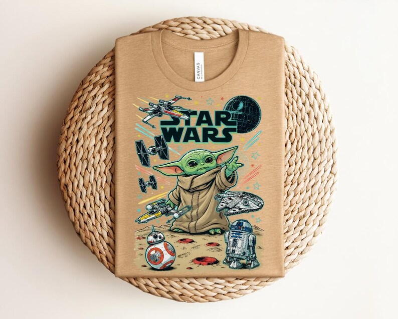Puede incluir: Una camiseta de color tostado con un estampado gr&aacute;fico que incluye el texto STAR WARS, un personaje alien&iacute;gena verde, una Estrella de la Muerte, un X-wing, cazas TIE, el Halc&oacute;n Milenario, BB-8 y R2-D2, con estrellas y l&iacute;neas de colores.