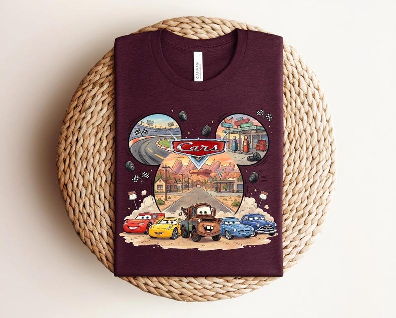 Puede incluir: Una camiseta de cuello redondo color granate con un gr&aacute;fico del logotipo y los personajes de Disney Pixar Cars, incluyendo a Rayo McQueen y Mate. El dise&ntilde;o tiene forma de cabeza de Mickey Mouse con escenas de carreras y Radiator Springs.