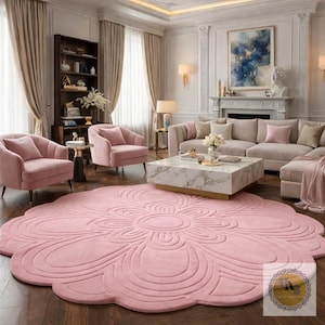 Puede incluir: Sal&oacute;n con una gran alfombra rosa claro con forma de flor. La habitaci&oacute;n incluye sillones de terciopelo rosa a juego, un sof&aacute; y una mesa de centro de m&aacute;rmol. Las paredes son blancas y las cortinas son de color beige neutro.