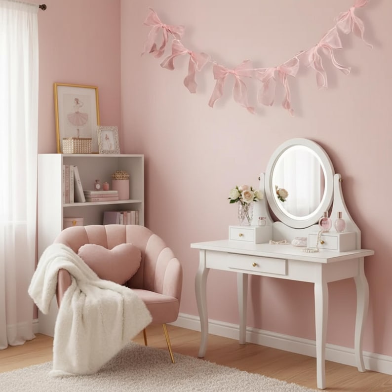 May include: A pink bedroom scene featuring a white vanity with a round mirror, a pink armchair with a heart-shaped pillow, and a white bookshelf. A fluffy white blanket is draped over the chair. Pink ribbon bows decorate the wall.