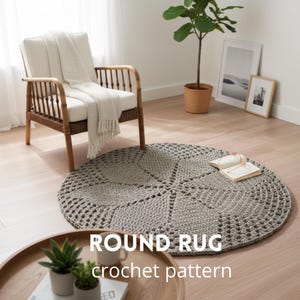 Puede incluir: Una alfombra redonda de ganchillo gris con un patrón geométrico se muestra sobre un suelo de madera clara. La alfombra está cerca de una silla de mimbre con un cojín blanco y una manta. El texto "ROUND RUG crochet pattern" es visible.
