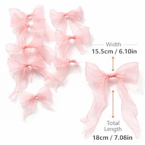 May include: A collection of light pink organza bows. The bows have a width of 6.10 inches (15.5cm) and a total length of 7.08 inches (18cm). The bows are delicate and airy, with long flowing tails. Ideal for crafting or embellishments.
