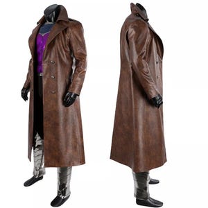 Può includere: Un lungo trench marrone a doppio petto con un ampio colletto e un design lungo e fluente. Il cappotto è abbinato a una camicia viola, guanti neri e stivali argento e neri. Il costume è esposto su un manichino.
