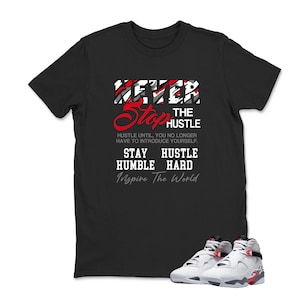 May include: Black t-shirt with the text "NEVER Stop the HUSTLE" in red and white. The shirt also has the phrases "Hustle until, you no longer have to introduce yourself", "Stay Humble Hard", and "Inspire The World". White and red sneakers are at the bottom.