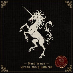 Pode incluir: Padrão de ponto cruz com um unicórnio branco empinando-se sobre um fundo preto. O unicórnio tem um chifre longo e uma crina esvoaçante. O texto "Hand drawn Cross stitch patterns" está abaixo.
