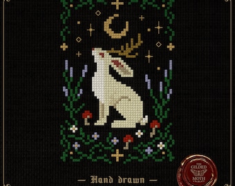 May include: Cross-stitch pattern featuring a white rabbit with antlers, gazing upwards towards a crescent moon and stars. The design includes green foliage, mushrooms, and the text "Hand drawn Cross stitch patterns" on a black background.