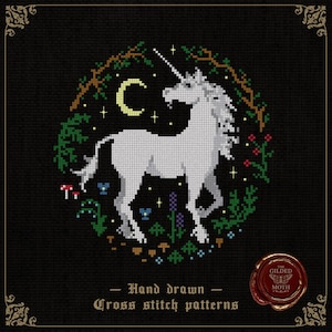 Può includere: Uno schema a punto croce con un unicorno bianco all'interno di una ghirlanda circolare di fogliame verde, piccoli funghi rossi e una luna crescente gialla su sfondo nero. Il testo recita Hand drawn Cross stitch patterns.