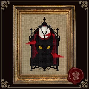 May include: Cross-stitch art of a black cat with yellow eyes, framed in gold. The cat is set against a gothic arch with red and white accents. The artwork is on a tan background and includes a red wax seal with the text "The Gilded Moth".