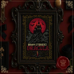May include: Framed cross-stitch art featuring a gothic design with a red full moon, a silhouette of a castle, and the text "Bram Stoker's Dracula." The artwork is in a black ornate frame. A red wax seal with a butterfly logo is in the lower right corner.