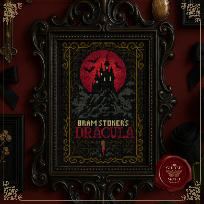 May include: Framed cross-stitch art featuring a gothic design with a red full moon, a silhouette of a castle, and the text "Bram Stoker's Dracula." The artwork is in a black ornate frame. A red wax seal with a butterfly logo is in the lower right corner.