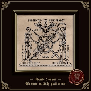 May include: A framed cross stitch pattern on beige fabric featuring two skeletons, a central skull with wings, an hourglass, a scythe, and a sword. Latin text includes MOMENTUM UNDE PENDET, AETER NITAS, VITE ET MORTIS, HUC CRUX DUCIT, HUC VOLUPTAS, and ELIGE.