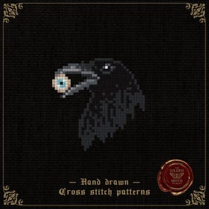 May include: A cross stitch pattern featuring a black raven head in profile holding a human eyeball in its beak. The design is set against a black background with the text Hand drawn Cross stitch patterns and a red wax seal with a moth icon.