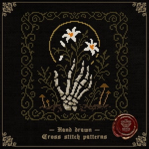 May include: Cross-stitch pattern featuring a skeletal hand holding white flowers with orange centers, set against a black background. The design includes a gold halo, brown mushrooms, and decorative borders. Text reads "Hand drawn Cross stitch patterns".