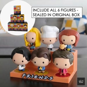 May include: A set of six Friends character figurines displayed on an orange stand with the show's logo. The figurines are in a cartoon style, each with unique outfits and hairstyles. The text "INCLUDE ALL 6 FIGURES - SEALED IN ORIGINAL BOX" is visible.