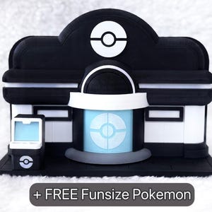 May include: A black and white model of a building featuring a central circular emblem, a light blue door, and a small matching side console. A dark gray rectangular label at the bottom displays the text + FREE Funsize Pokemon in white letters.