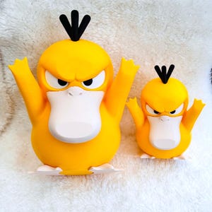 May include: Two yellow duck-like figures with white bellies, white feet, and black hair tufts on their heads. Both figures have angry facial expressions with furrowed brows and wide, flat beaks. The figures are standing side by side in different sizes.