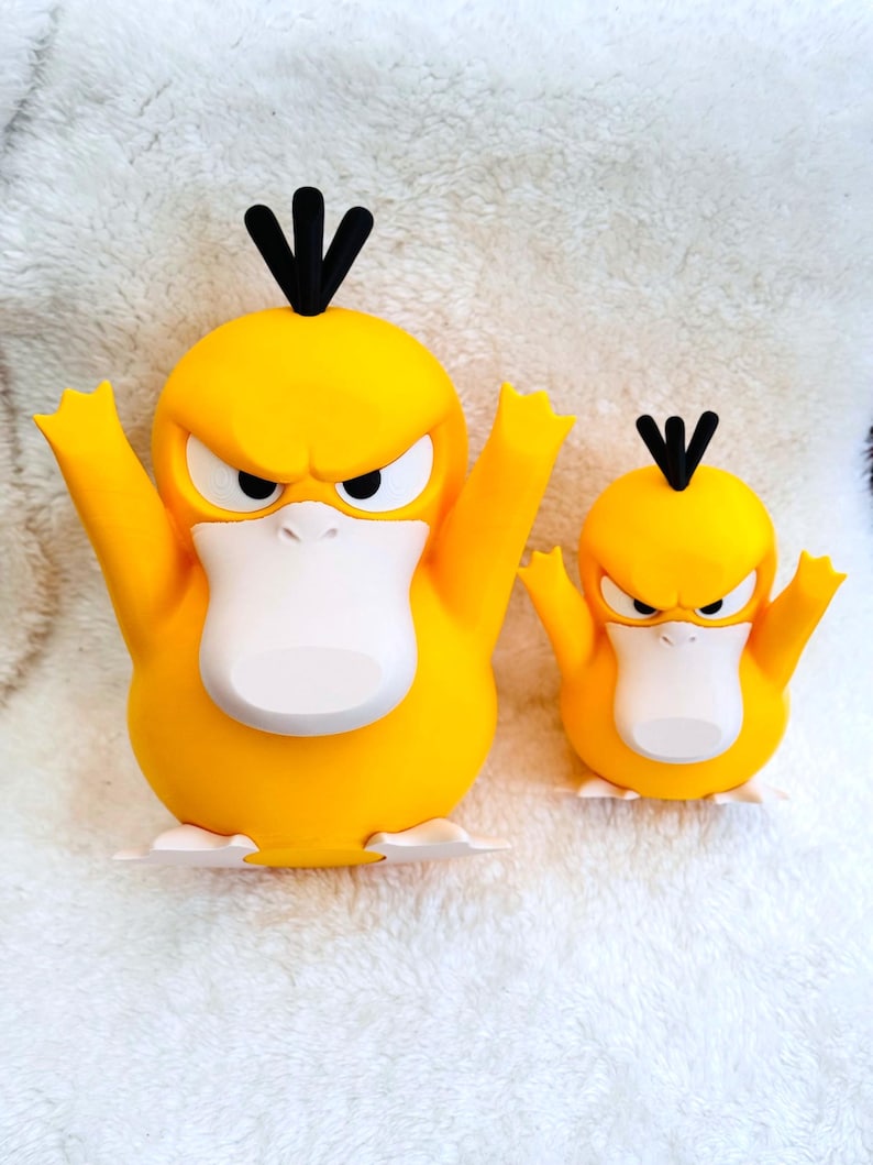 May include: Two yellow duck-like figures with white bellies, white feet, and black hair tufts on their heads. Both figures have angry facial expressions with furrowed brows and wide, flat beaks. The figures are standing side by side in different sizes.