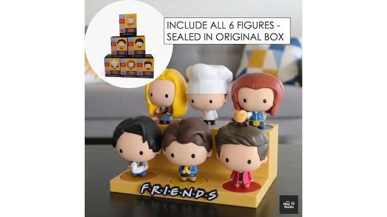 May include: A set of six Friends character figurines displayed on a yellow stand with the show's logo. The figurines have large heads and are in various outfits. The text "INCLUDE ALL 6 FIGURES - SEALED IN ORIGINAL BOX" is visible.