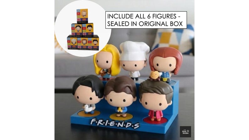 May include: A set of six Friends character figurines displayed on a blue base with the show's logo. The figurines are in a cartoon style, each with unique outfits and hairstyles. The text "INCLUDE ALL 6 FIGURES - SEALED IN ORIGINAL BOX" is visible.