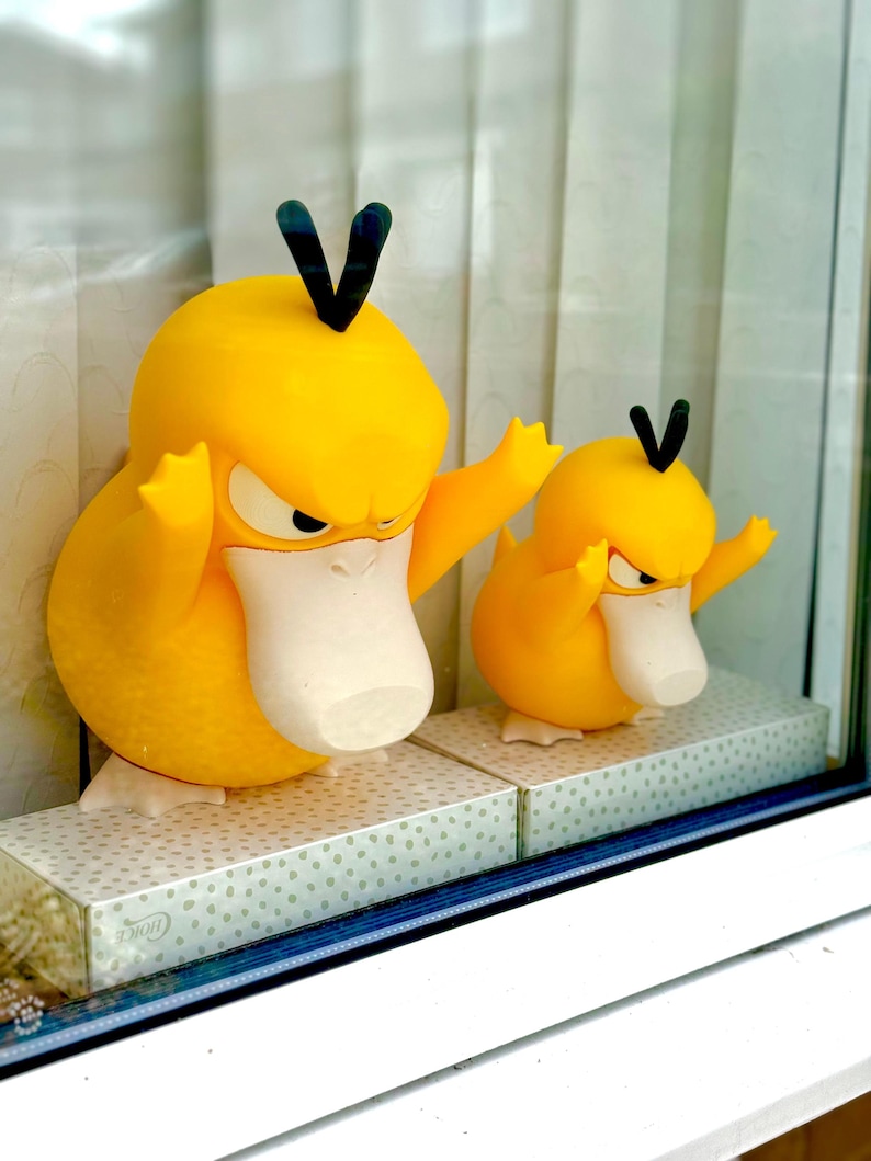 Puede incluir: Dos figuras amarillas parecidas a patos con picos blancos y mechones de pelo verde oscuro en la cabeza. Ambas figuras tienen expresiones de enfado con cejas fruncidas, brazos levantados y pies blancos. Est&aacute;n colocadas una al lado de otra.