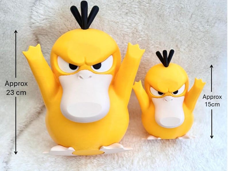 May include: Two yellow duck-like figures with black hair tufts, white beaks, and white feet. The larger figure measures approximately 9.06 inches in height, while the smaller figure measures approximately 5.91 inches in height.