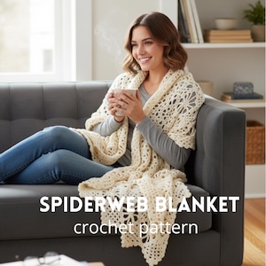 Puede incluir: Una manta de telaraña de ganchillo de color crema, drapeada sobre una persona sentada en un sofá gris. La manta presenta un diseño calado. El texto "SPIDERWEB BLANKET crochet pattern" se muestra en la imagen.