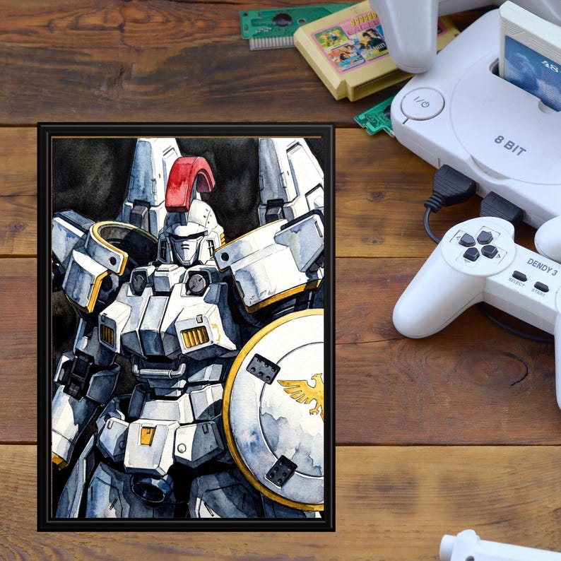 A framed mecha model illustration propped on a warm wooden desk next to vintage 8-bit game cartridges and a retro console setup. This high-detail mobile suit gundam print captures a textured watercolor portrait of the Tallgeese unit, blending nostalgic gaming vibes with classic robot art.