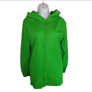 May include: A bright green hooded jacket with a zipper closure. The jacket has a waffle-like texture and a relaxed fit.