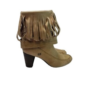 May include: Tan suede ankle boots with a fringe detail around the top. The boots have a rounded toe, a stacked heel, and a decorative stitch pattern. The heel height is approximately 3 inches.