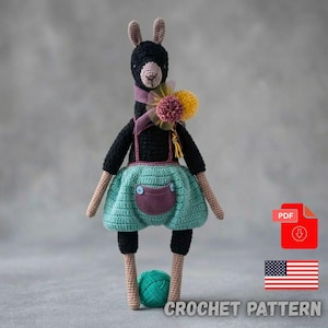 May include: A black crocheted llama doll with tan limbs, wearing teal bloomers with a purple pocket and two blue buttons. The llama has a purple ribbon and yellow and pink pom-poms around its neck. A teal yarn ball sits between its feet.