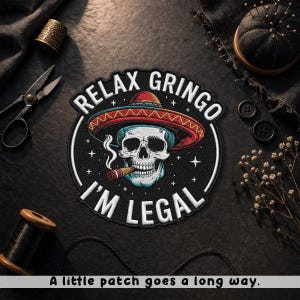 May include: Embroidered patch featuring a skull wearing a sombrero and smoking a cigar. The text "RELAX GRINGO I'M LEGAL" is displayed around the skull. The patch is black with white, red, and blue accents. The phrase "A little patch goes a long way" is at the bottom.