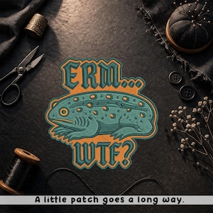 May include: Embroidered patch featuring a teal and orange lizard with the text "ERM... WTF?". The patch is surrounded by sewing notions, including scissors, a thimble, and a pin cushion. The text "A little patch goes a long way" is at the bottom.