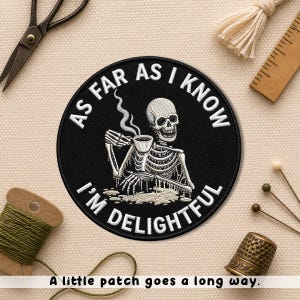 May include: Black round patch with the text "AS FAR AS I KNOW I'M DELIGHTFUL" and an illustration of a skeleton holding a cup of coffee. The patch also has the text "A little patch goes a long way."