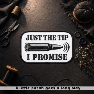 May include: A black and white patch with the text "JUST THE TIP I PROMISE" and a bullet illustration. The patch is rectangular with a white border. The phrase "A little patch goes a long way" is at the bottom.