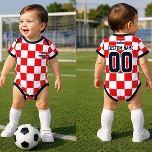 May include: A baby bodysuit featuring a red and white checkered pattern, dark blue trim, and a small Croatian flag emblem on the chest. The back displays the text CUSTOM NAME above the number 00 in dark blue with a white outline and a flag.