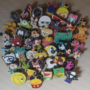 May include: A collection of Disney character pins, including Mickey Mouse, Minnie Mouse, Winnie the Pooh, and other popular characters. The pins are colorful and feature various designs, such as character faces, logos, and themed objects.