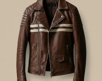 May include: Brown leather jacket with white stripes across the chest. The jacket has a classic biker style with a notched collar, zippered pockets, and quilted shoulder detailing. The jacket is made of a rich brown leather.