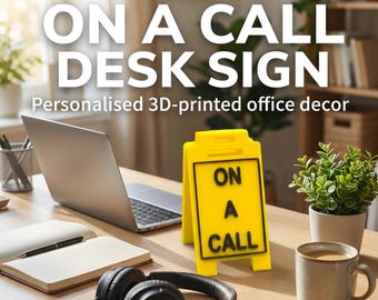Puede incluir: Un letrero de escritorio amarillo brillante en forma de A con el texto negro en relieve ON A CALL. Este letrero de plástico impreso en 3D se mantiene en posición vertical sobre una superficie plana para indicar disponibilidad en la oficina.