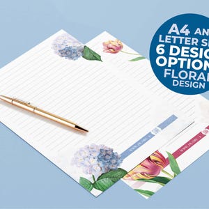 Op de afbeelding: Twee vellen gelinieerd briefpapier met bloemillustraties van blauwe hortensia's en roze tulpen. Een gouden pen ligt op het papier. De tekst bevat "www.jw.org" en een cirkelvormige afbeelding met "A4 AND LETTER SIZE 6 DESIGN OPTIONS FLORAL DESIGN".